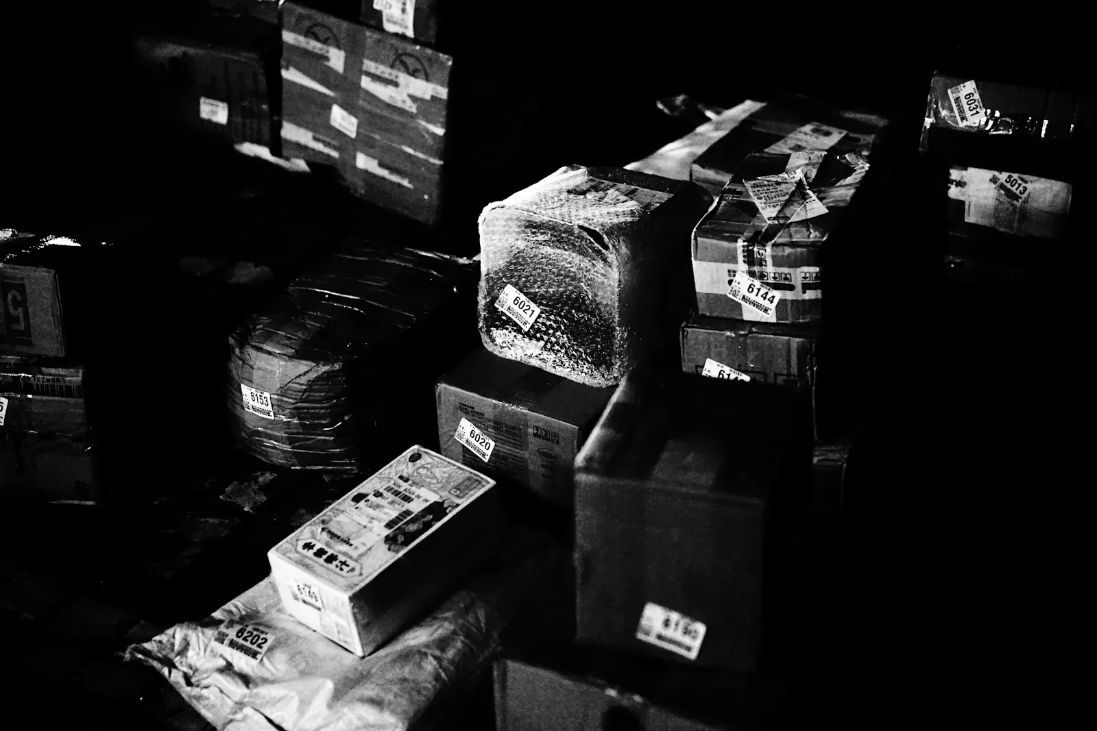 Cardboard shipping boxes stacked together in low, even light